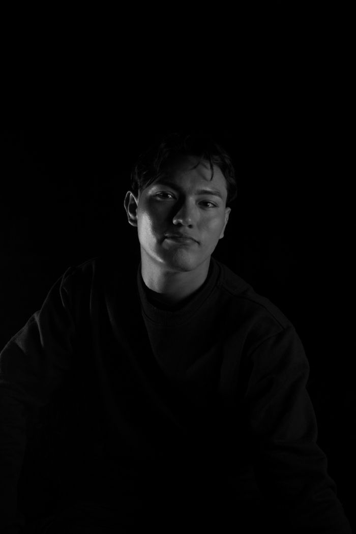 Young man in a dark studio, lit by a single soft light from the side