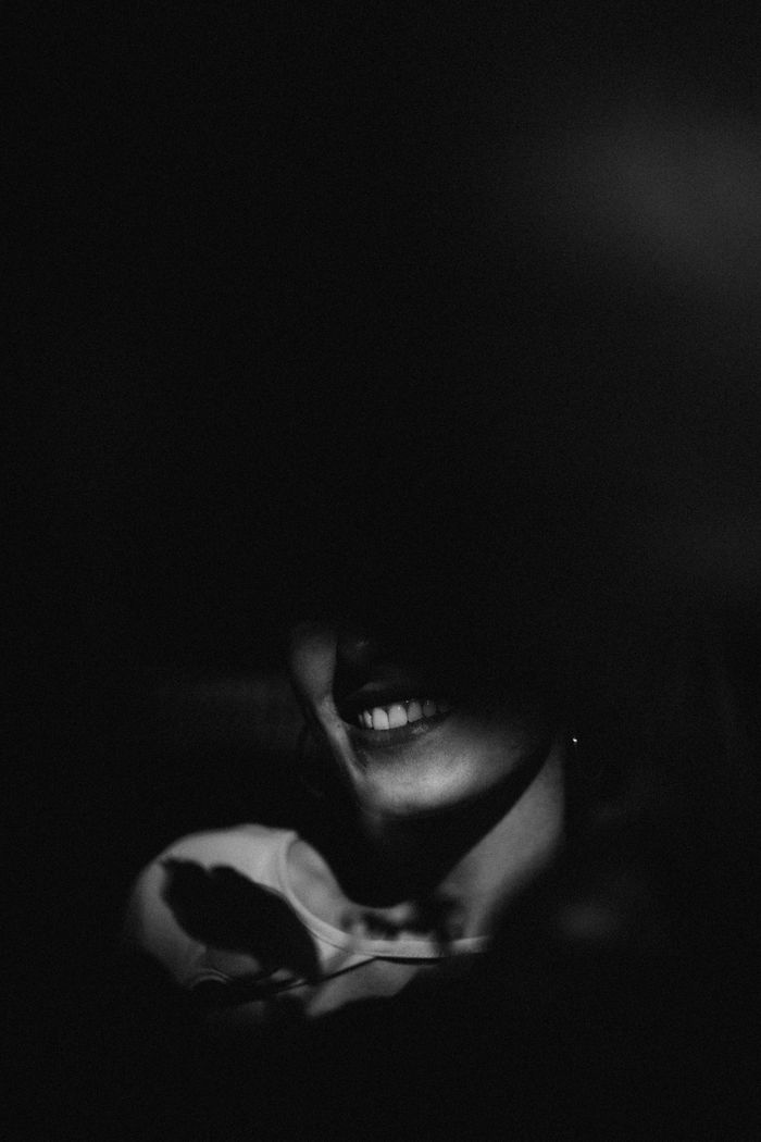 Smiling woman half hidden in shadow, black and white